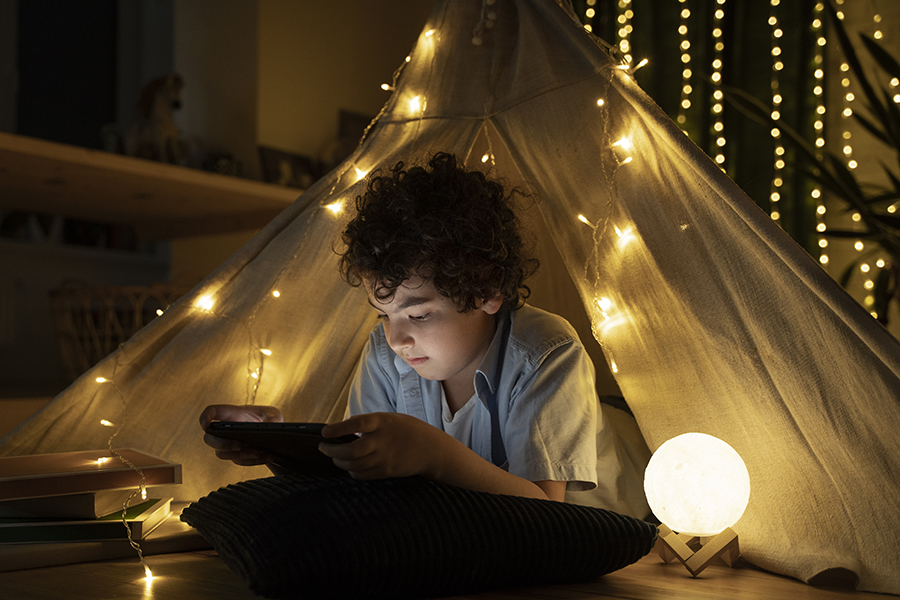 close up op lezend kind in zijn huistent - verlichting voor de kinderkamer