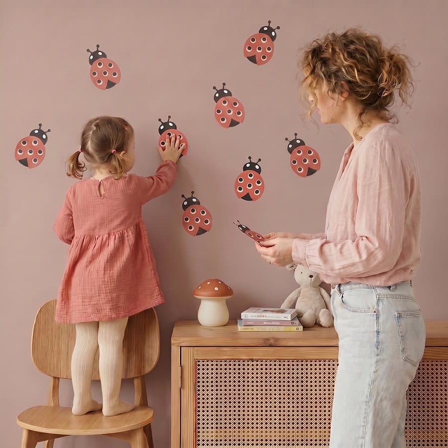 Kleine muurstickers met lieveheersbeestjes 1 Moeder en dochter plakken rode lieveheersbeestje muurstickers op de kinderkamer muur — set van 5 stuks